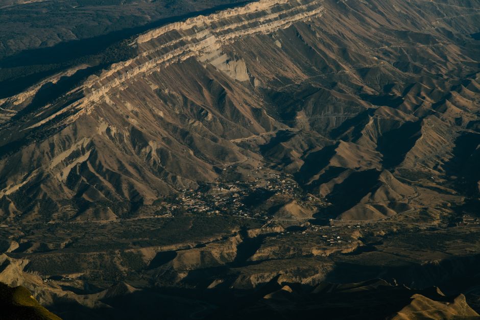 A stunning aerial shot of a rural village nestled in a rugged mountain landscape.