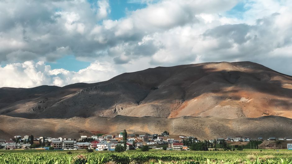 Panoramic view of hills and a small town under a cloudy sky in Adıyaman, Turkey.